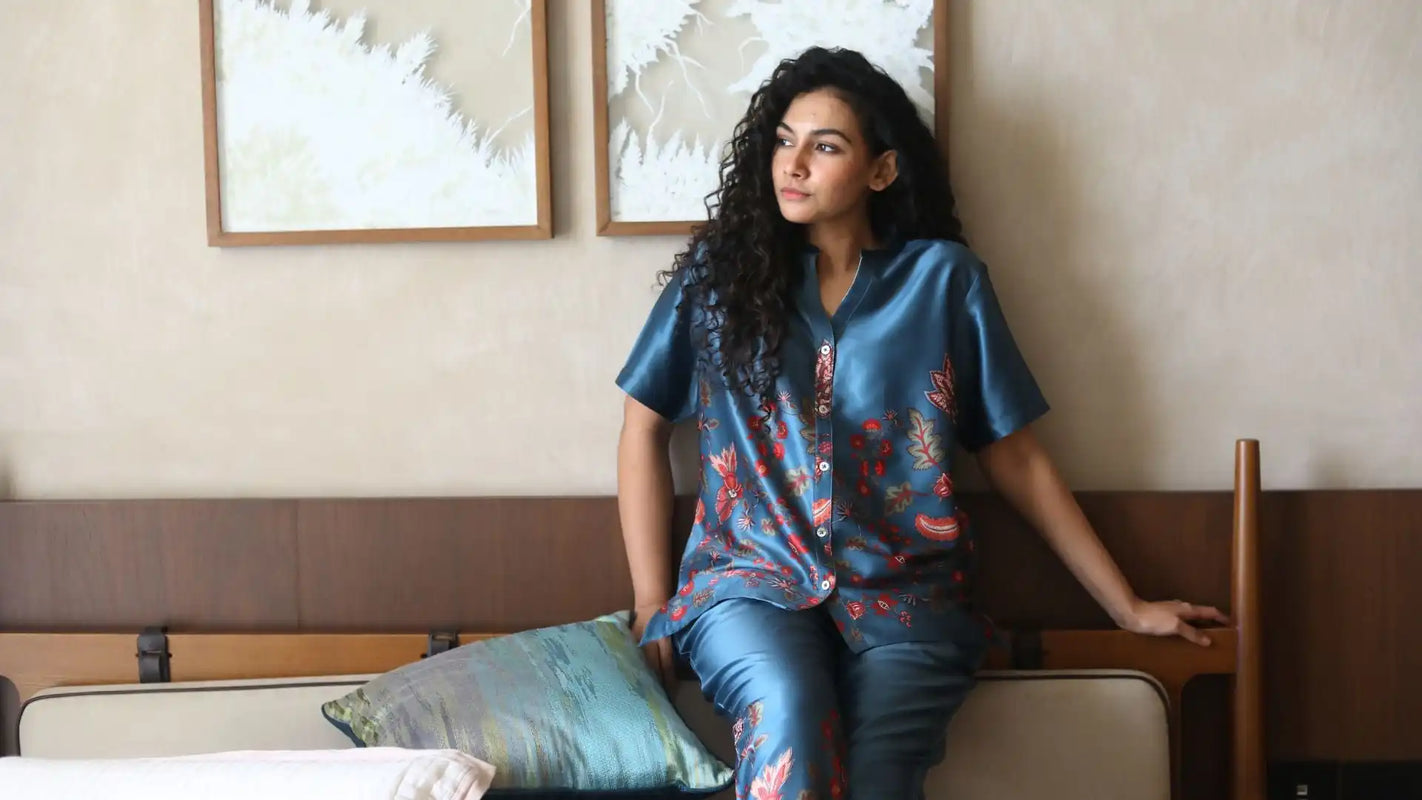 Woman in a blue floral print silk pajama set.