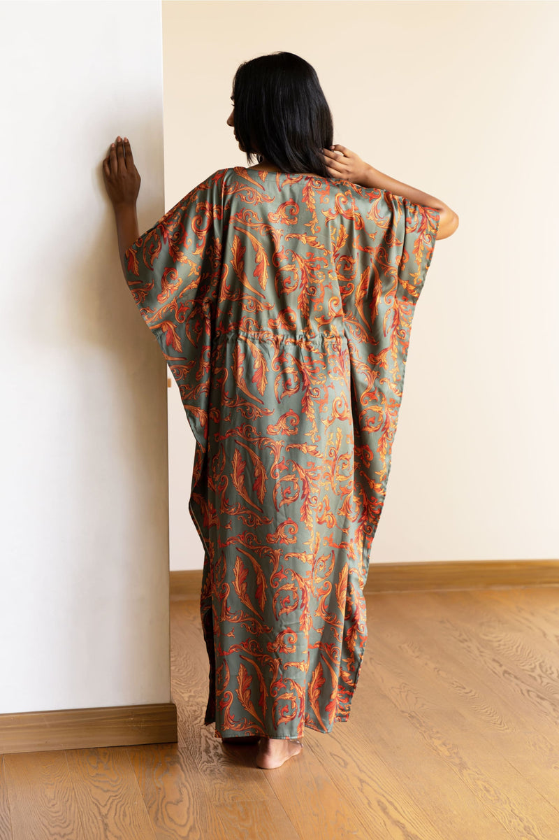 The kaftan is an  ankle length long dress with flowy sleeves, made from smooth man made fibre, with a drawstring at the waist. It's free size and comfortable to lounge in.